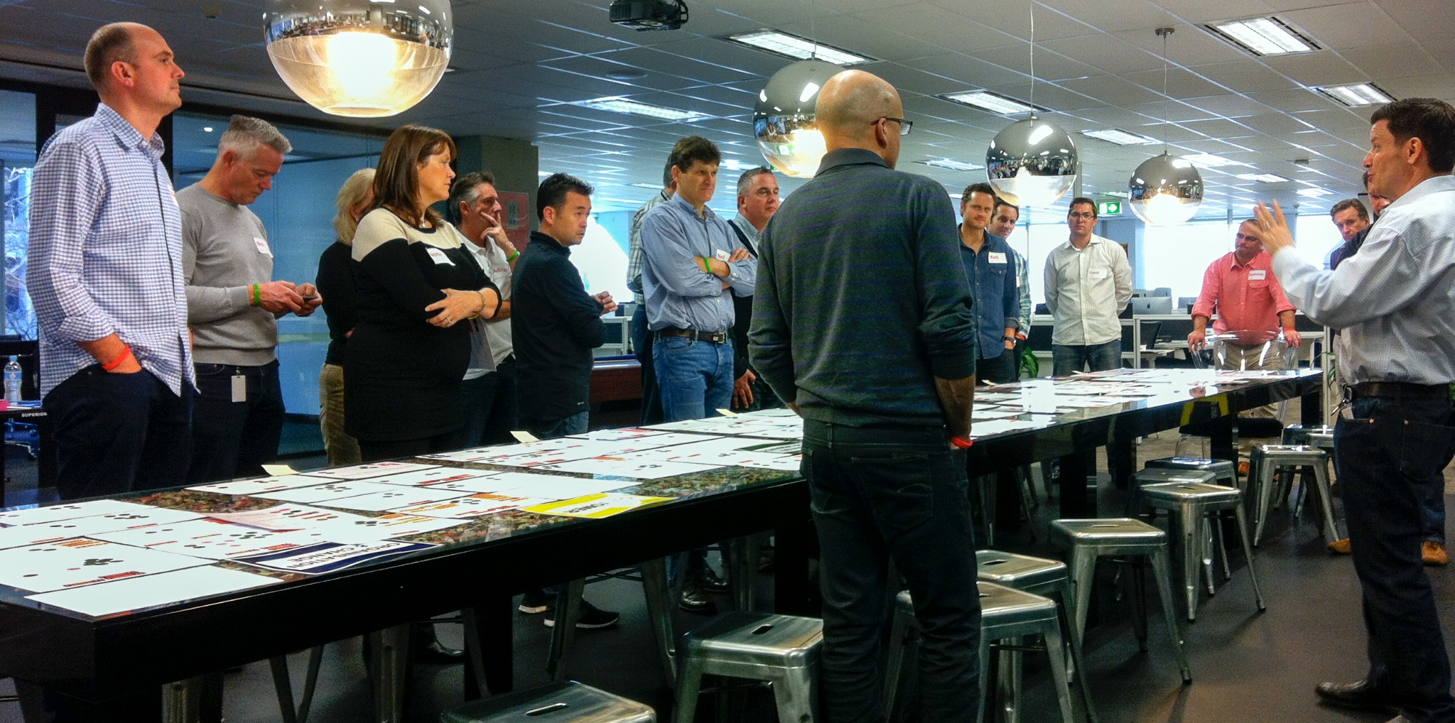 Participants collaborating around a table and storyboard wall during a Fundamental Academy working session.